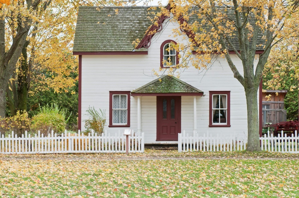 A white house with a picket fence. A white house with a picket fence.