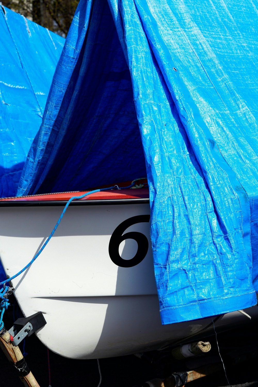 Blue tarp over white boat Blue tarp over white boat