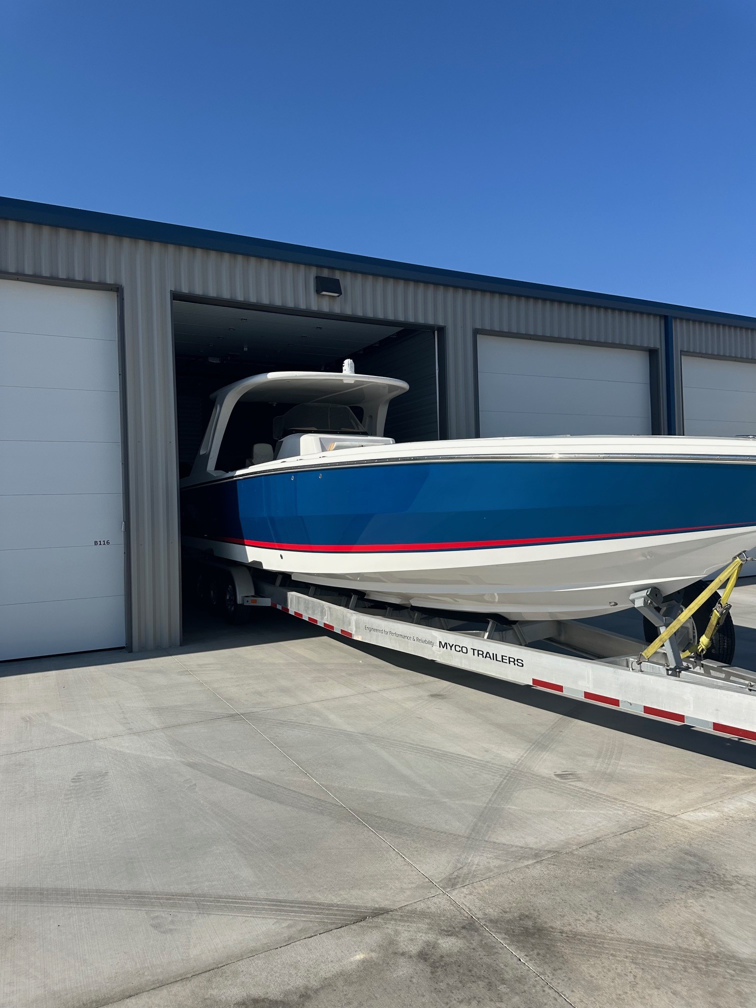 Large luxury boat parked safely inside a premium, fully enclosed storage unit with 14-foot tall doors at Showplace Storage in Lake Havasu.