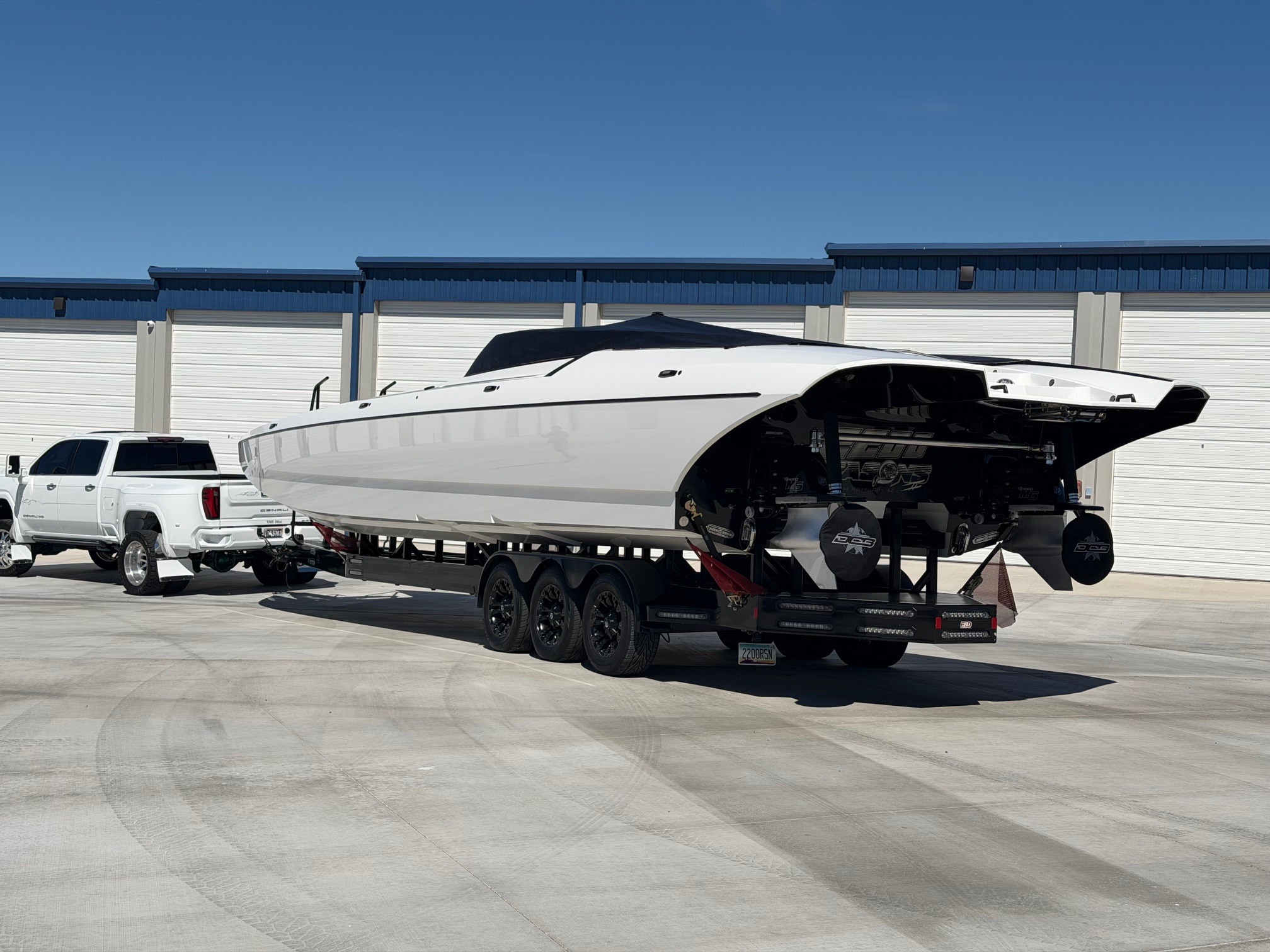 A large white high-performance powerboat and truck easily navigating the extra-wide concrete driveways at High Octane Storage in Lake Havasu.
