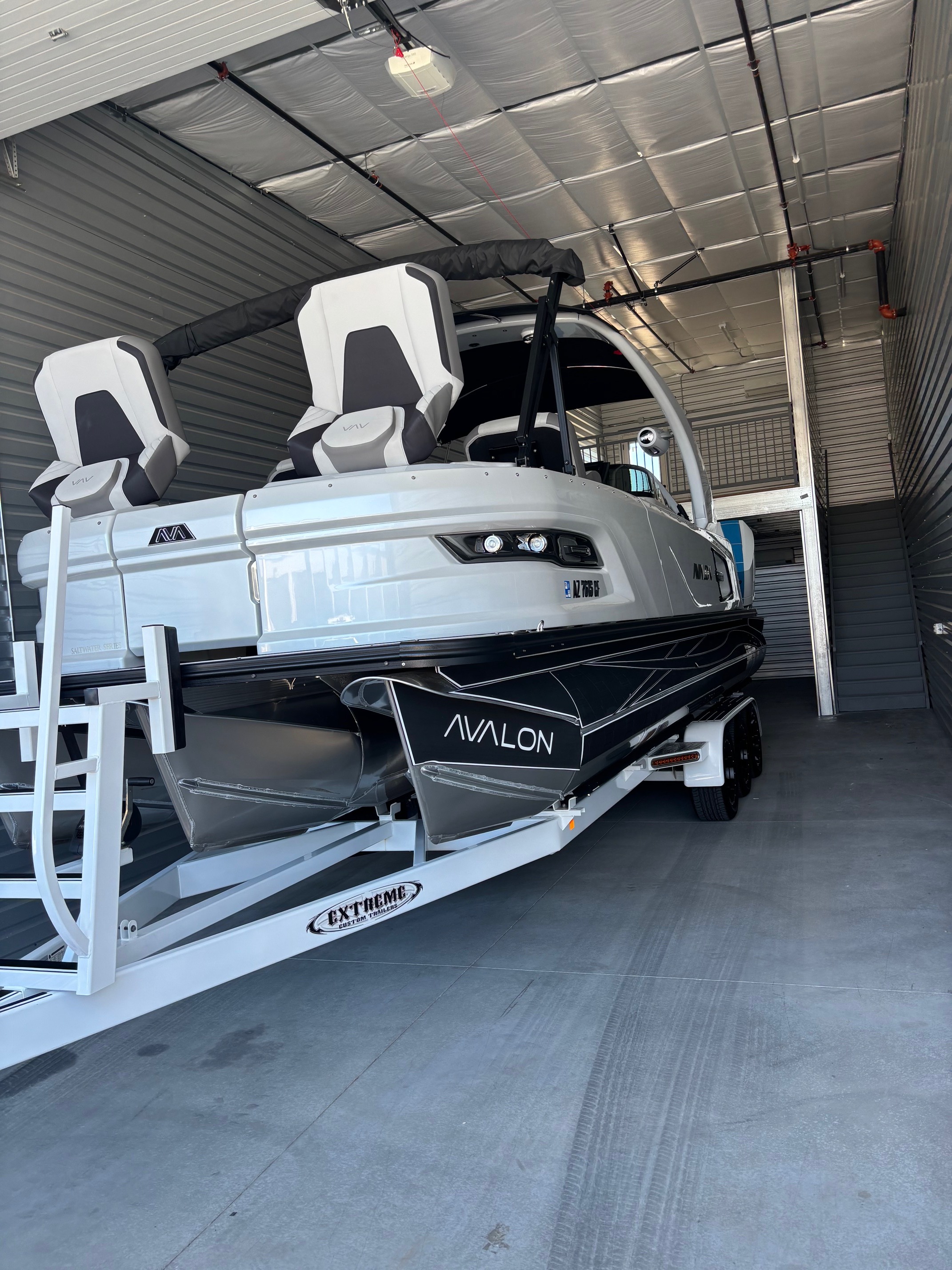 Large high-performance luxury boat with twin motors parked inside at High Octane Storage.
