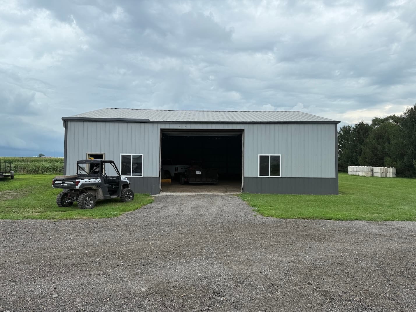 Wide front view of the Route 54 Storage indoor boat and RV storage facility in Farmer City, Illinois, with a bay door open and trailers stored inside near Clinton Lake