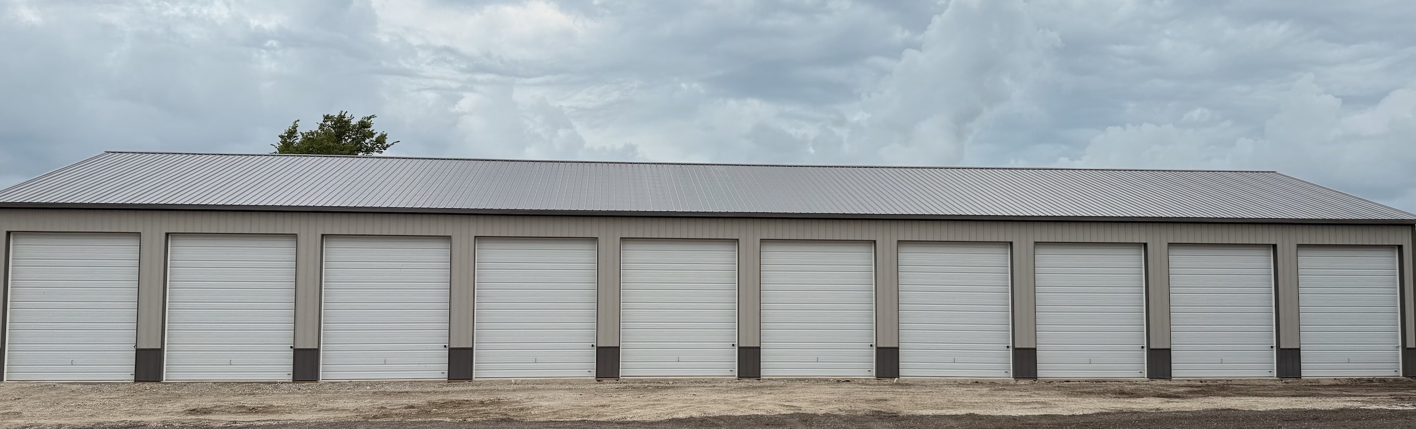 Long row of brand-new indoor boat and RV storage units with white roll-up doors at Route 54 Boat & RV Storage near Clinton Lake in Parnell, Illinois