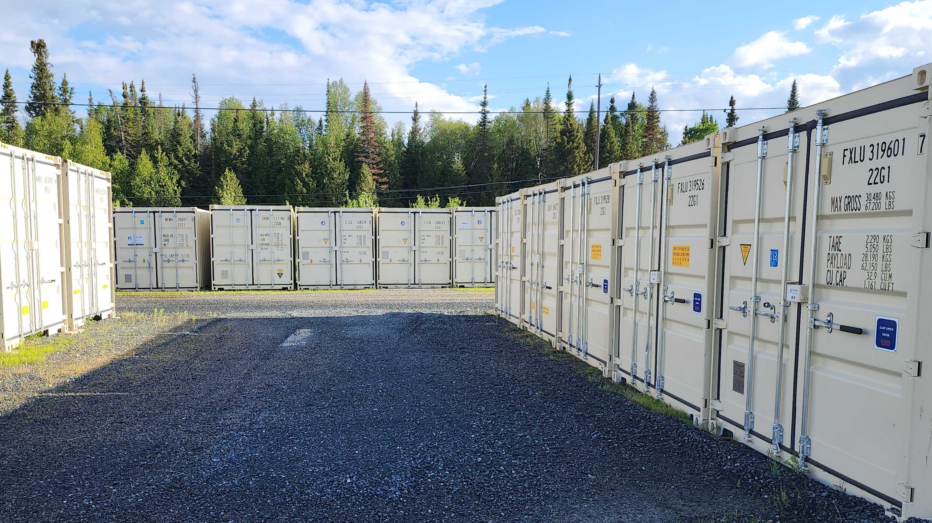 Drive-up self storage containers at DAM Reliable Storage in Kenora, Ontario, featuring secure steel storage units with wide access lanes.