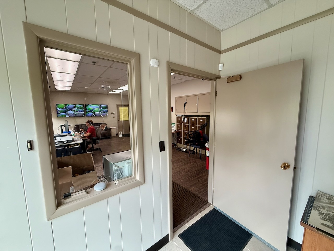 The reception window and office interior at Southbury Self Storage with staff at the desk
