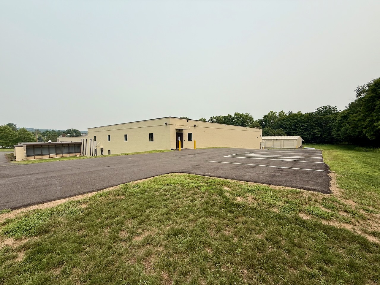 The upper level parking lot alongside Building 2 at Southbury Self Storage, freshly paved and striped
