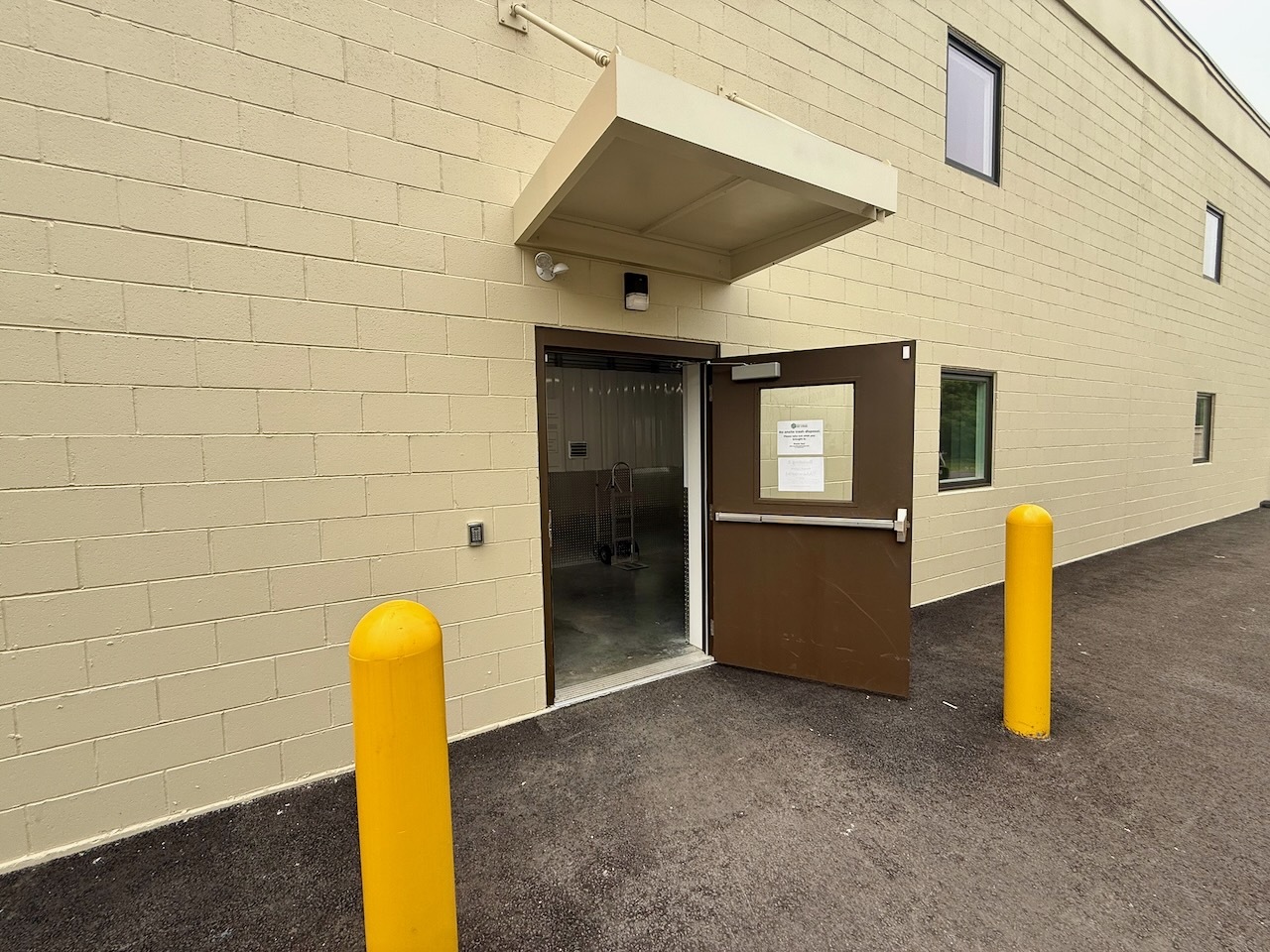 The lower level rear entrance to Building 2 at Southbury Self Storage with yellow bollards and a canopy