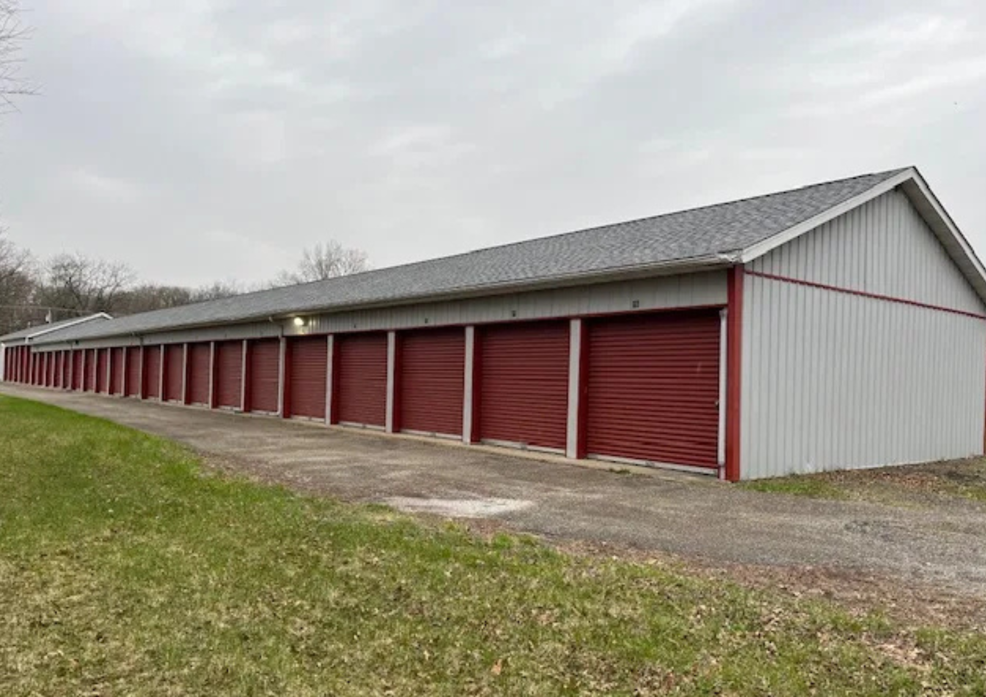 Long exterior row of red drive-up storage unit doors at a self storage facility in Knox.