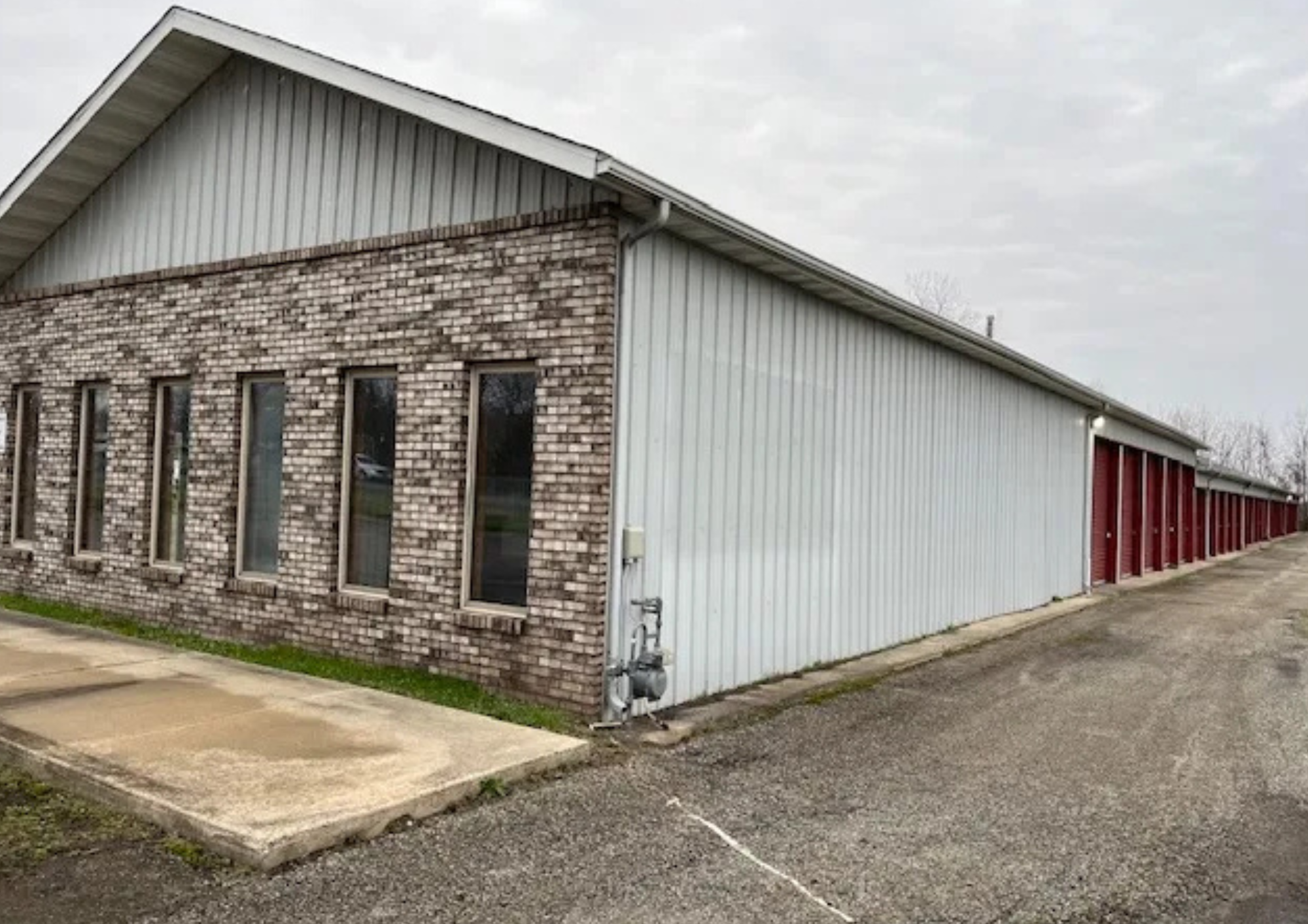 Brick storage facility office beside a row of drive-up storage units in Knox.