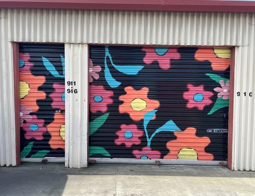 Storage roll-up doors painted with a bright flower mural