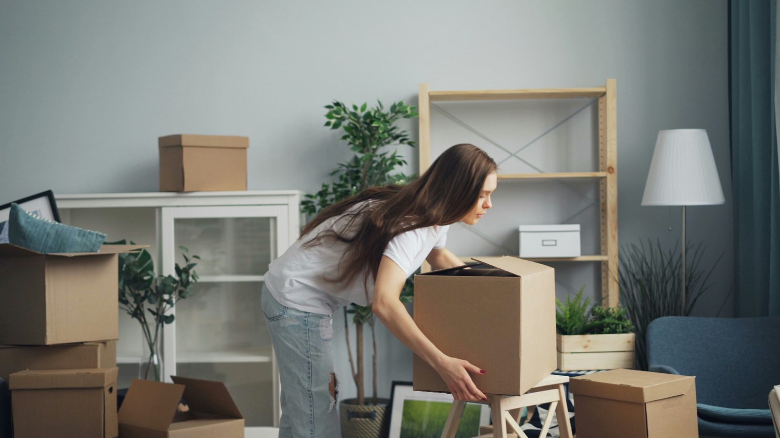 Woman packing boxes while preparing a seasonal home for storage Woman packing boxes while preparing a seasonal home for storage
