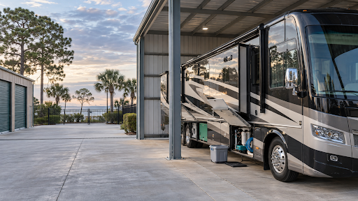 Class A motorhome parked under covered storage at a gated storage facility in Fairhope, Alabama.