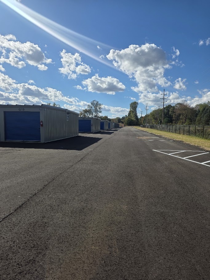 Paved drive alongside storage buildings and marked outdoor spaces at Handy Storage.