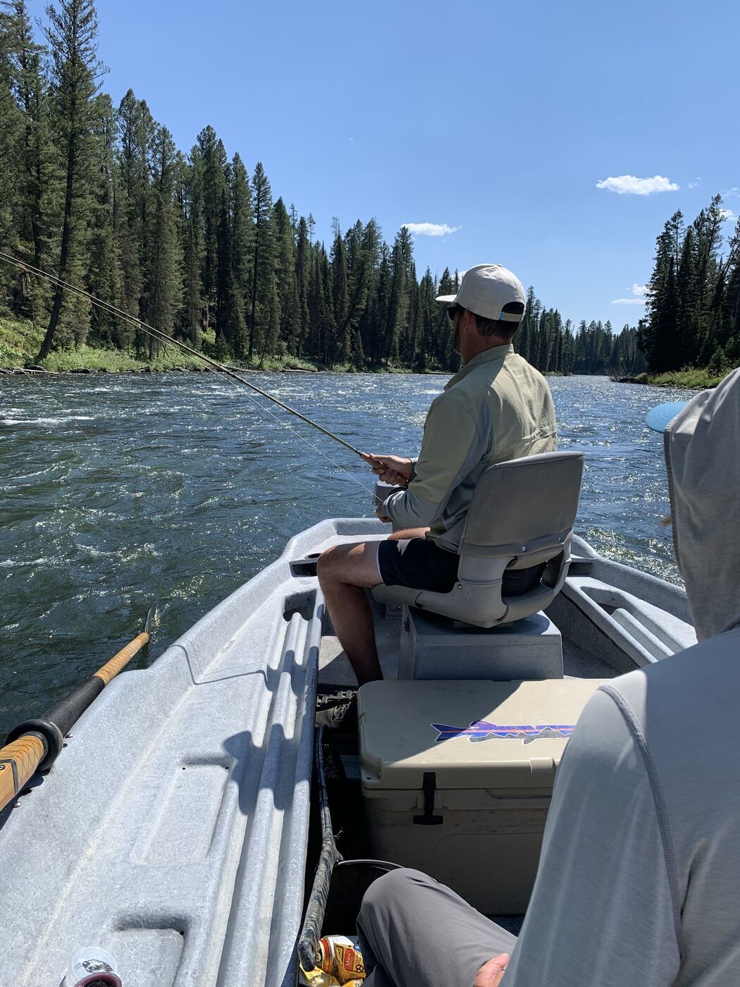 Fly fishing from a drift boat on the Henry's Fork Fly fisherman in a drift boat on the Henry's Fork in Island Park, Idaho