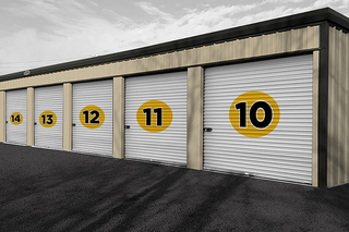Storage building with white roll-up doors at Unique Self Storage in Sebring, FL.