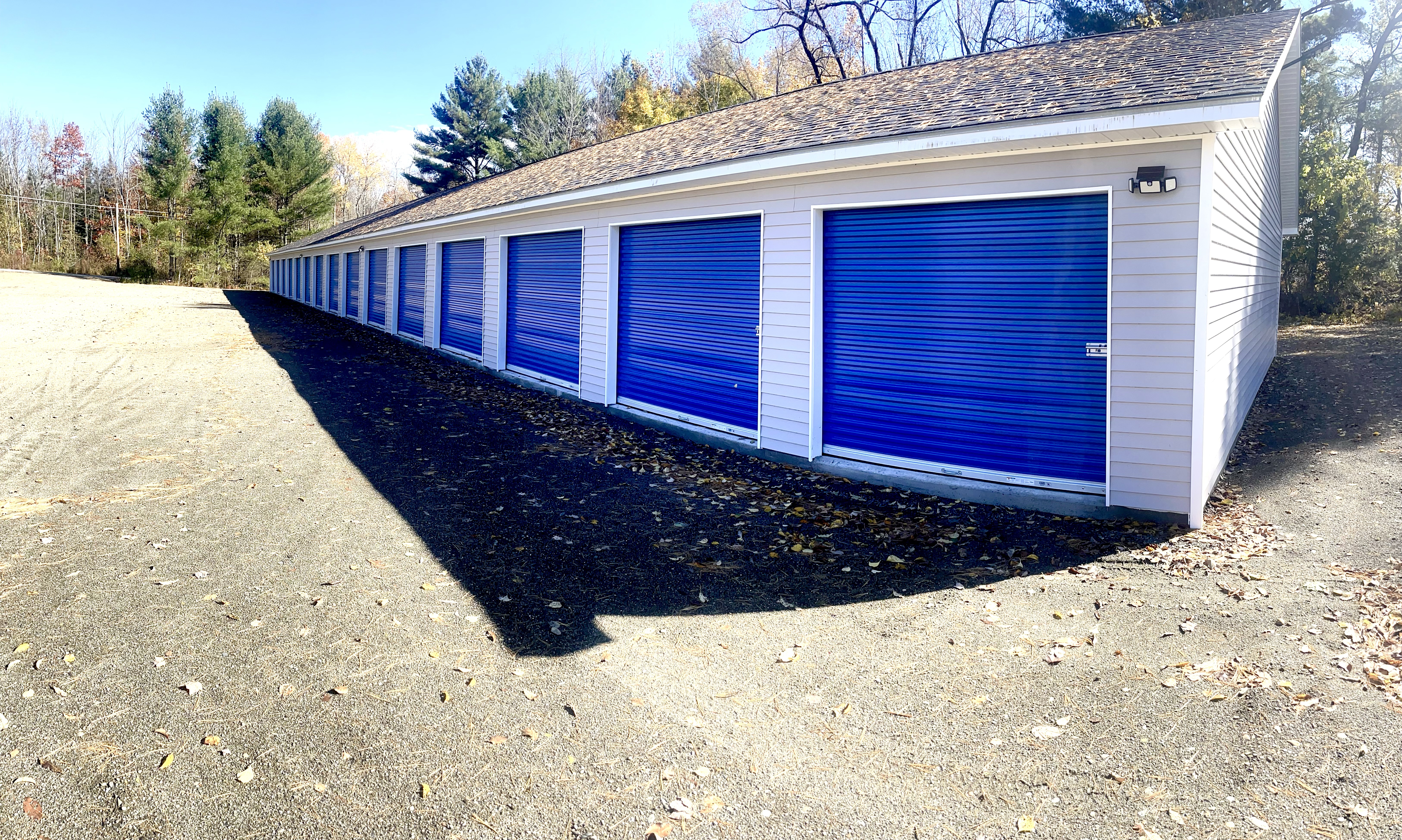 Row of cobalt-blue drive-up storage unit doors at SDG Self Storage on Webb Road, Waterville, Maine